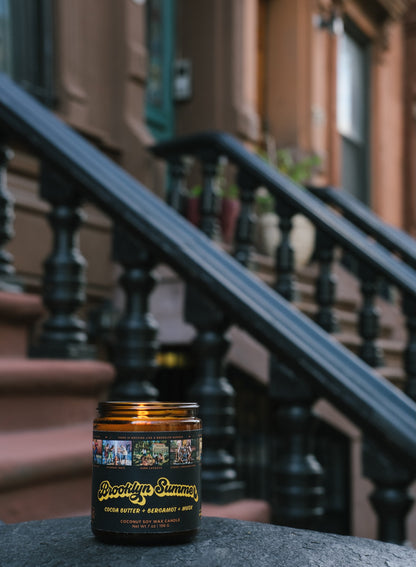 Candle with a label in front of a brownstone building