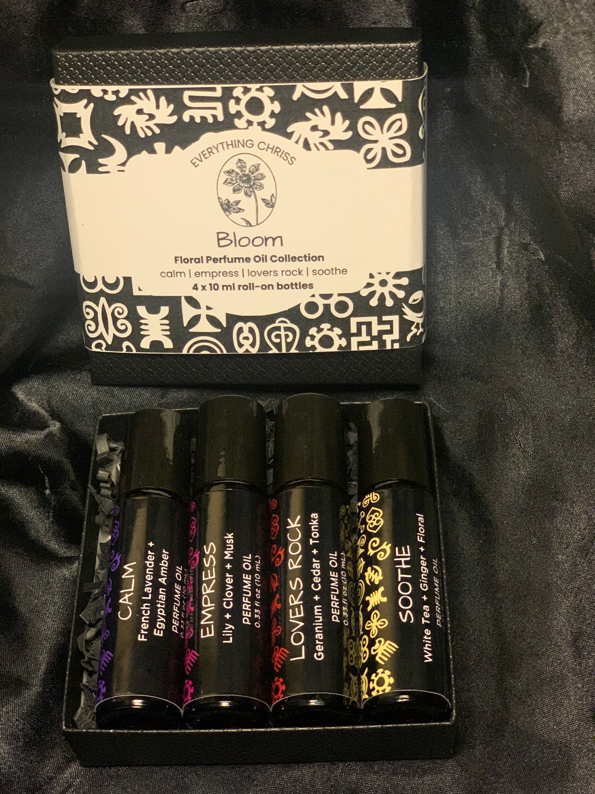 Set of perfume oils with decorative packaging on a black background